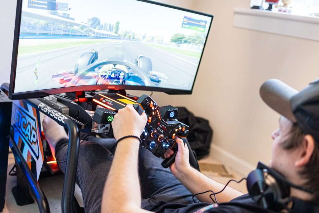 A person driving in a sim rig with Asatek equipment.